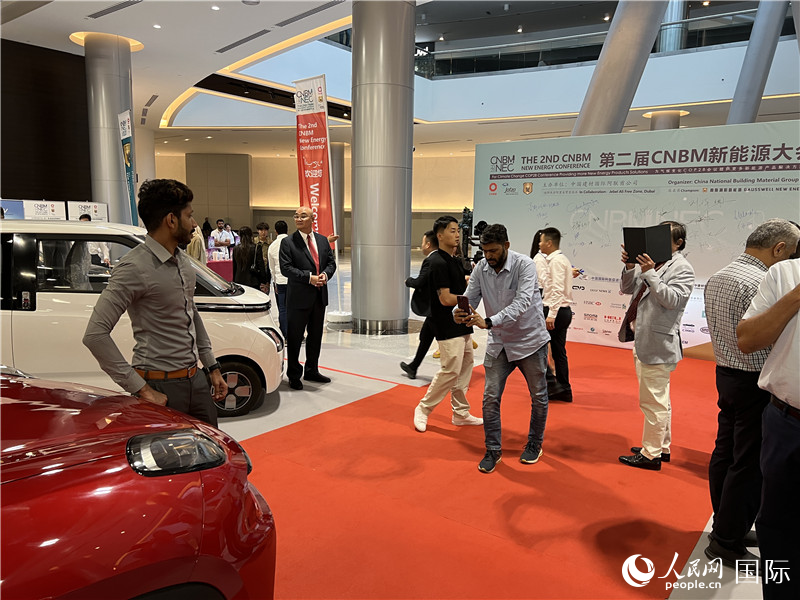 在新能源大会上，现场观众与中国新能源汽车合影。人民网记者 张志文摄